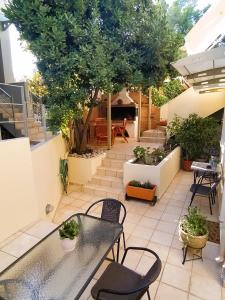 a patio with a table and chairs and trees at Esperos Nafplio in Nafplio