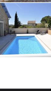 einen Pool mit blauem Wasser im Hinterhof in der Unterkunft Winemaker’s House with pool near the sea in Saint-Geniès-de-Fontedit
