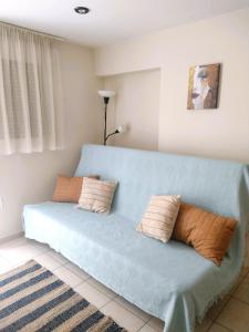 um sofá azul com duas almofadas num quarto em Esperos Nafplio em Nafplio