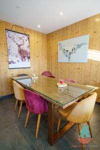 ラルプ・デュエズにあるAlpe d'Huez Houses - Chez Stella - 3 chambres neuf plein centreの木製のテーブルと椅子のあるダイニングルーム