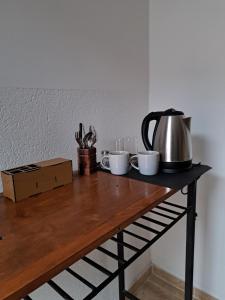 - une table avec 2 tasses et une bouilloire dans l'établissement Hostal El soleado, à Navarro