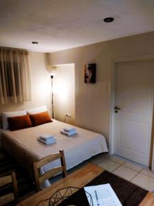 a bedroom with a bed and a table and a door at Esperos Nafplio in Nafplio
