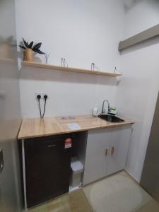 uma cozinha com um lavatório e uma bancada em Midnight Homestay Youth City em Nilai