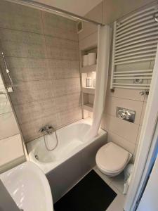 a bathroom with a toilet and a tub and a sink at Kleine weisse Doppelhaushälfte in Częstochowa