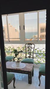 a table and chairs with a view of the ocean at appartement plage mahdia sable dor in Kenitra