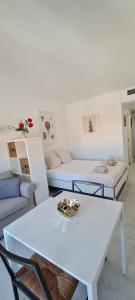 Sala de estar blanca con 2 mesas y sofá en Loft Triana Sevilla, en Sevilla