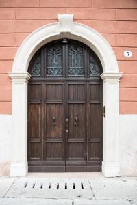 a large wooden door in a building with an arch at Residenza Duomo3 - Apartments in Verona