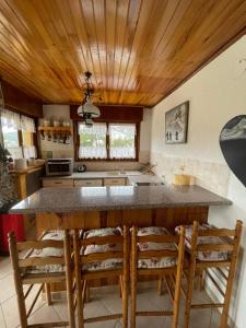 een keuken met een houten plafond en een aanrecht met stoelen bij Gréolières La Floconnière in Gréolières