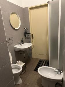 a bathroom with a sink and a toilet and a mirror at Pearl Pisa guest house in Pisa