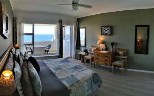 a bedroom with a bed and a desk and a table at Penguinden - Private Villa with Sea Views in Cape Town