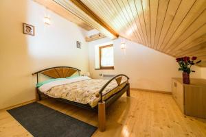 Tami في Lokve: غرفة نوم بسرير وسقف خشبي