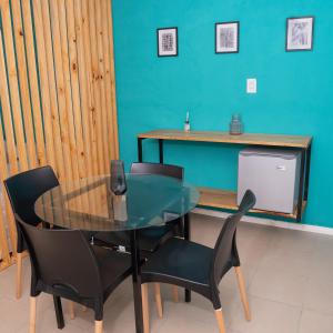 una sala da pranzo con tavolo in vetro e sedie nere di Alta Pinta a Paso de los Libres