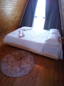 a bed sitting in a room with a window at Cottage "Sunset" in Batumi