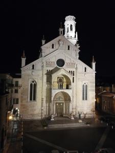 a large white church with a clock tower at night at Residenza Duomo3 - Apartments in Verona