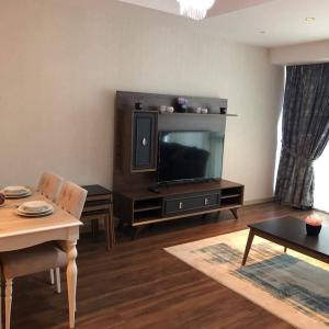 ein Wohnzimmer mit einem TV und einem Tisch in der Unterkunft low price luxury apartment city center in Istanbul