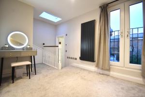baño con tocador, lavabo y ventana en Stunning 3 Bed Apartment, en Londres