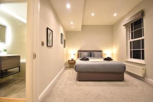 a bedroom with a large bed and a bathroom at Stunning 3 Bed Apartment in London