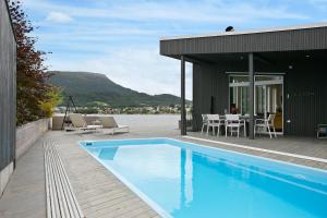une maison avec une piscine à côté d'un bâtiment dans l'établissement Fantastisk sommerhus i Tennfjord, ved Ålesund., à Tennfjord