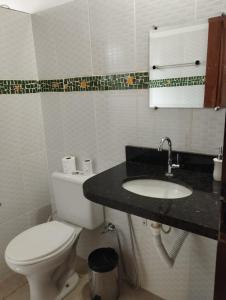 a bathroom with a toilet and a sink at Pousada Luz do Sol in Sao Jorge