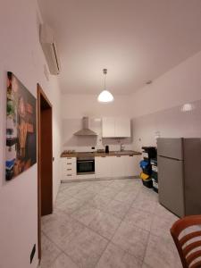 a large kitchen with white cabinets and a refrigerator at I ciclamini in Monopoli