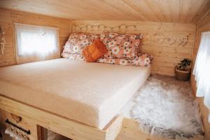 a bed in a wooden cabin with a rug at Malý kúsok raja in Reľov