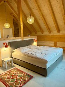 uma cama grande num quarto com tectos em madeira em Ferienwohnung im Loft-Style mit Sauna im historischen Schwarzwaldhof em Simonswald