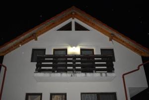 a white building with a balcony at night at Capra cu trei iezi in Sinaia