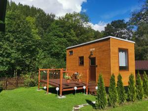 a tiny house with a bench in a yard at Malý kúsok raja in Reľov