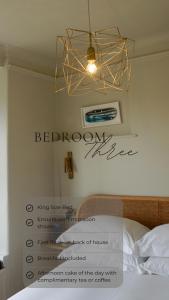 a chandelier hanging over a bed in a bedroom at The Sandy Duck in Falmouth