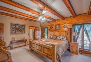 a bedroom with a large bed and wooden walls at Buffalo River Lodge St Joe AR in Maumee
