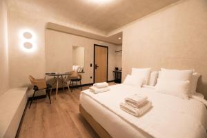 een slaapkamer met een wit bed en handdoeken bij AthensOwl in Athene