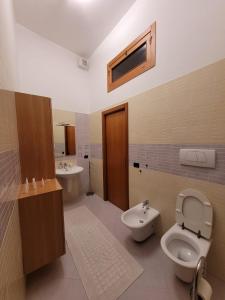 a bathroom with a toilet and a bidet and a sink at I ciclamini in Monopoli