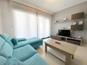 La Horadada的住宿－Appartement Mil palmeras，客厅配有蓝色的沙发和茶几