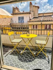 - Balcón con mesa amarilla y 2 sillas en Hypercentre terrasse clim, en Aix-en-Provence