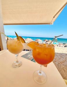 La HoradadaにあるAppartement Mil palmerasのビーチを背景にテーブルの上でカクテル2杯