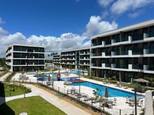un complejo con piscina y un edificio en Makia Beach By BMS, en Porto de Galinhas