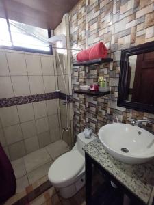 łazienka z toaletą i umywalką w obiekcie Palm house Arenal w mieście Fortuna