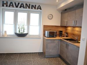 cocina con fregadero, microondas y ventana en Gästehaus Radler Scheune en Heede