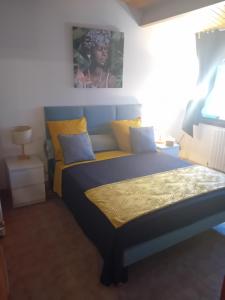 a bedroom with a bed with yellow and blue pillows at La Coraillaise in Saint-Aigulin