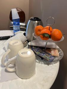 a table with a cup and a plate of oranges at Candia Rooms in Rome