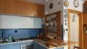 - une cuisine avec des murs bleus et des placards en bois dans l'établissement Il Girasole, à Milan