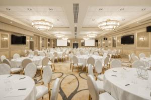 - une salle de banquet avec des tables et des chaises blanches dans l'établissement The Ebrington Hotel, à Derry Londonderry