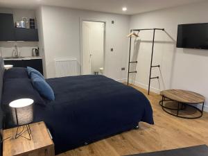 a bedroom with a large blue bed and a table at Green haven in Winford