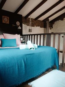1 dormitorio con 1 cama con manta azul en La Faya - La Vallicuerra Casas Rurales en Mieres