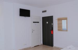 Habitación con puerta y TV en la pared en Apartamenty Południowa, en Szczecin