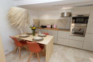 eine Küche mit einem Holztisch und einigen Stühlen in der Unterkunft CASA Farniente Appartement Cocooning Provence Verte in Montfort-sur-Argens