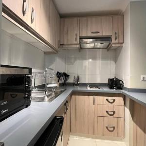 a kitchen with a sink and a stove top oven at Nuevo y cómodo Departamento en Pucón in Pucón