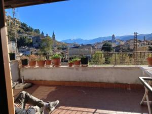 a person sitting on a balcony with a view of a city at La chiave dei tre Abruzzi in Popoli