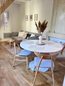 a living room with a white table and chairs at Le Jeanne, appartement en duplex proche forteresse et centre ville in Chinon