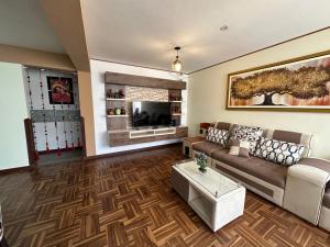 - un salon avec un canapé et une télévision dans l'établissement PAKARINA HOUSE, à Cusco